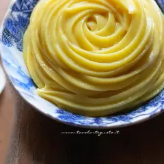Crema pasticcera senza uova, liscia e vellutata, servita in una ciotola decorata con motivi blu.