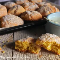 Biscotti al latte appena sfornati, spolverati di zucchero a velo, pronti per essere inzuppati in una tazza di latte caldo.