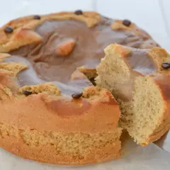 Una deliziosa torta al caffè, con una fetta tagliata e chicchi di caffè a decorare la glassa lucida.