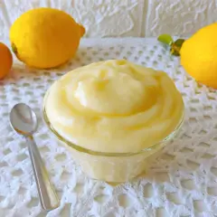 Crema pasticcera al limone, soffice e profumata, pronta per essere gustata. Accanto, un uovo e limoni freschi.