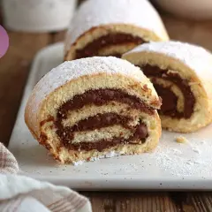 Fette di rotolo alla Nutella, soffice e goloso, cosparse di zucchero a velo.