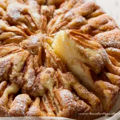 Una torta di mele umida e soffice, con un impasto dorato e mele caramellate, spolverata di zucchero a velo.