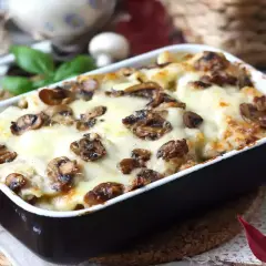 Un invitante pasta al forno con funghi e formaggio fuso, pronto per essere gustato.