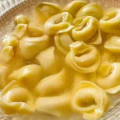 Un primo piatto caldo e confortante: tanti tortellini in brodo dorato, pronti per essere gustati.