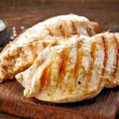 Petto di pollo alla griglia, perfetti secondi di carne da preparare in anticipo. Un contorno di sale completa l'immagine.