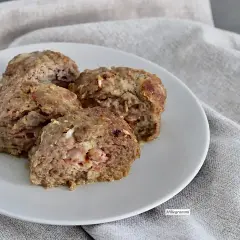Quattro fette di polpettone al forno morbido, con ripieno di prosciutto e formaggio, servite su un piatto bianco.