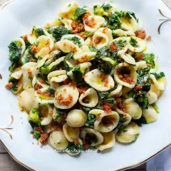 Un piatto invitante di orecchiette con cime di rapa, condite con olio d'oliva e pangrattato croccante.