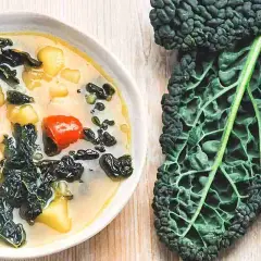 Zuppa cremosa con fagioli, pomodorini e cavolo nero. Ideale per cavolo nero ricette veloci e salutari.
