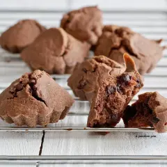 Deliziosi biscotti al cioccolato, alcuni interi e uno spezzato che rivela gocce di cioccolato fondente.