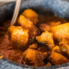 Un saporito spezzatino con patate, cotto lentamente e servito in una ciotola di pietra.