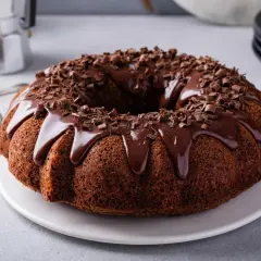 Torta al cioccolato con glassa lucida e riccioli di cioccolato, pronta per essere gustata.