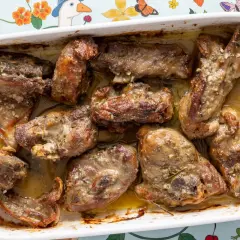 Pezzi succulenti di abbacchio alla romana cotti in teglia, con erbe aromatiche e succo saporito.