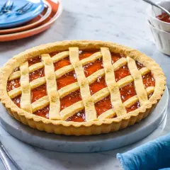 Una deliziosa crostata di marmellata con una griglia dorata di pasta frolla, pronta per essere gustata.