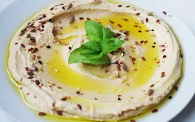 Cremoso hummus di ceci, condito con olio d'oliva, semi misti e una foglia di basilico fresco.