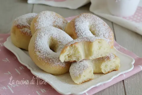 Ciambelle al forno soffici e profumate, cosparse di zucchero a velo, pronte per una colazione golosa.