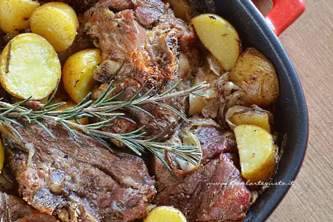 Succulento agnello al forno con patate dorate e rosmarino, un piatto che profuma di casa e tradizione.