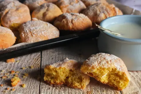 Biscotti al latte appena sfornati, spolverati di zucchero a velo, pronti per essere inzuppati in una tazza di latte caldo.