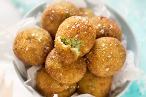 Polpette di zucchine e ricotta dorate e croccanti, cosparse di sale grosso. Una delizia da gustare!