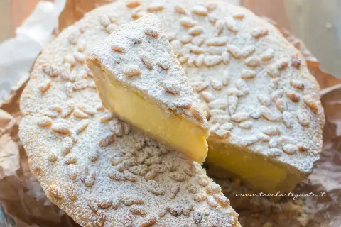La crostata della nonna, con la sua crema gialla e i pinoli tostati, è un dolce che profuma di casa.