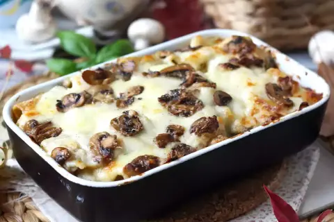 Un invitante pasta al forno con funghi e formaggio fuso, pronto per essere gustato.