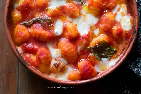Gnocchi alla sorrentina fumanti in terracotta, con pomodoro filante e basilico fresco. Un abbraccio di sapori.