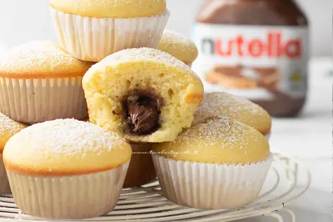 Muffin con cuore morbido di Nutella, una ricetta muffin semplici perfetta per ogni occasione. Spolverati di zucchero a velo.