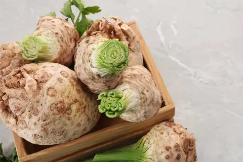 Sedano rapa freschi in una cassetta di legno, pronti per gustose ricette.