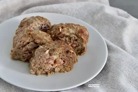 Quattro fette di polpettone al forno morbido, con ripieno di prosciutto e formaggio, servite su un piatto bianco.