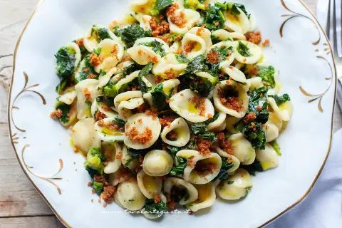 Un piatto invitante di orecchiette con cime di rapa, condite con olio d'oliva e pangrattato croccante.