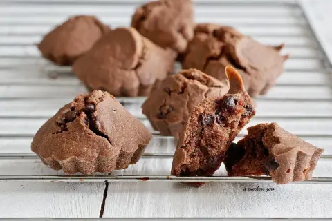Deliziosi biscotti al cioccolato, alcuni interi e uno spezzato che rivela gocce di cioccolato fondente.