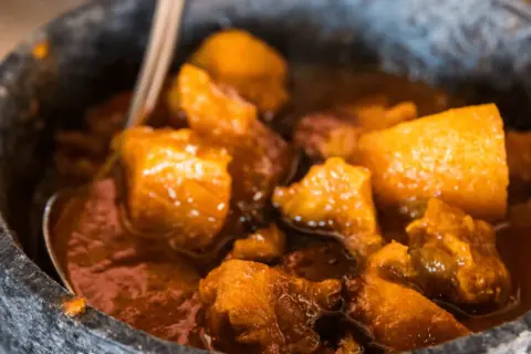 Un saporito spezzatino con patate, cotto lentamente e servito in una ciotola di pietra.