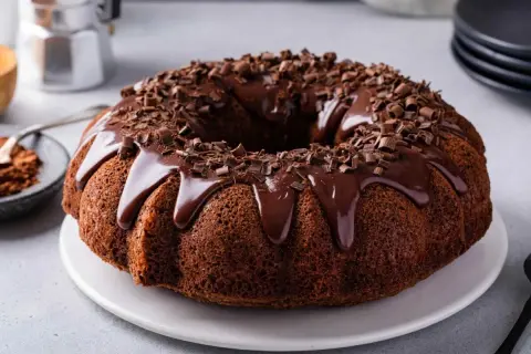 Torta al cioccolato con glassa lucida e riccioli di cioccolato, pronta per essere gustata.