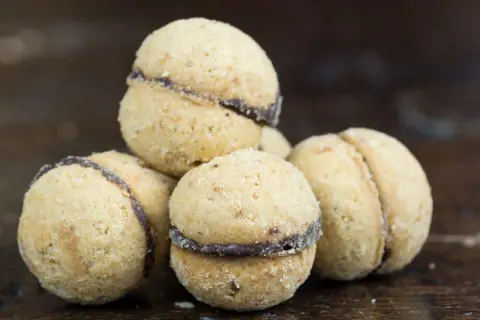 Baci di dama, deliziosi biscotti alle nocciole con un cuore di cioccolato, pronti per essere gustati.