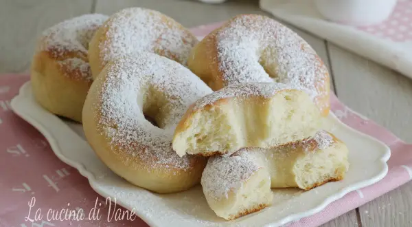 Ciambelle al forno soffici e profumate, cosparse di zucchero a velo, pronte per una colazione golosa.