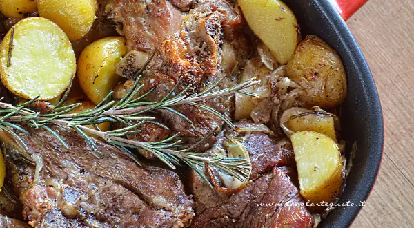 Succulento agnello al forno con patate dorate e rosmarino, un piatto che profuma di casa e tradizione.