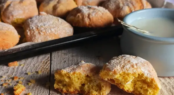 Biscotti al latte appena sfornati, spolverati di zucchero a velo, pronti per essere inzuppati in una tazza di latte caldo.