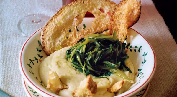 Piatto di fave e cicoria con crostini di pane abbrustolito. Un classico della cucina italiana, gustoso e salutare.