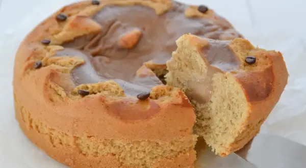 Una deliziosa torta al caffè, con una fetta tagliata e chicchi di caffè a decorare la glassa lucida.