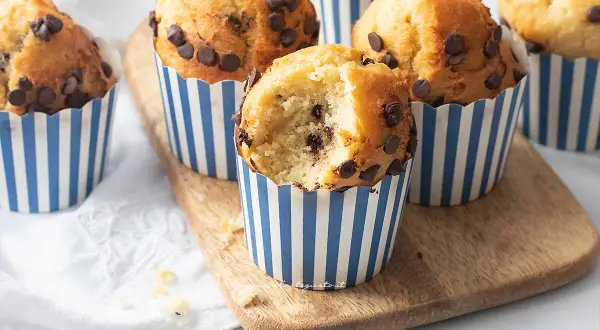 Muffin con gocce di cioccolato, perfetti per la friggitrice ad aria. Uno è stato morso, mostrando l'interno soffice.