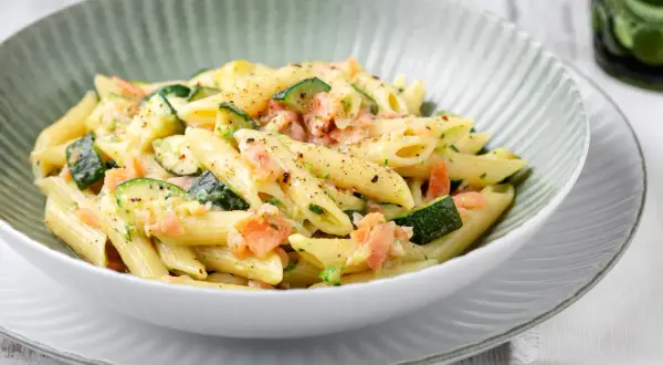 Penne con salmone e zucchine, un piatto cremoso e saporito, condito con erbe fresche e pepe nero.