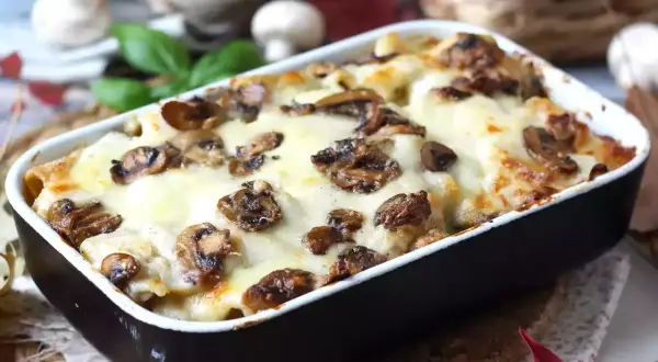 Un invitante pasta al forno con funghi e formaggio fuso, pronto per essere gustato.