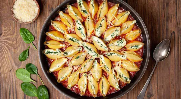 Conchiglioni ripieni al forno, un piatto invitante con pasta a forma di conchiglia farcita e gratinata, pronta per essere gustata.