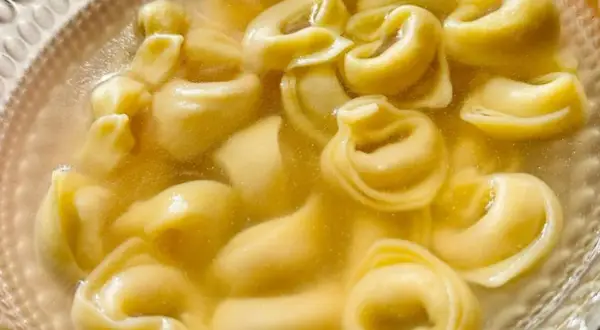Un primo piatto caldo e confortante: tanti tortellini in brodo dorato, pronti per essere gustati.