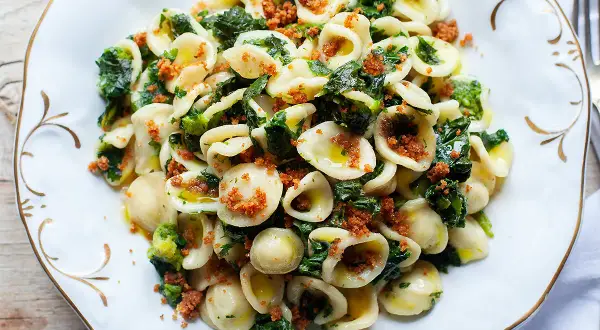 Un piatto invitante di orecchiette con cime di rapa, condite con olio d'oliva e pangrattato croccante.