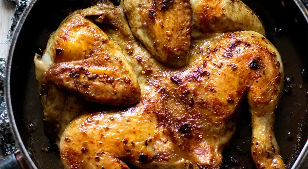 Pollo alla diavola dorato e succulento, cotto in padella con spezie piccanti.