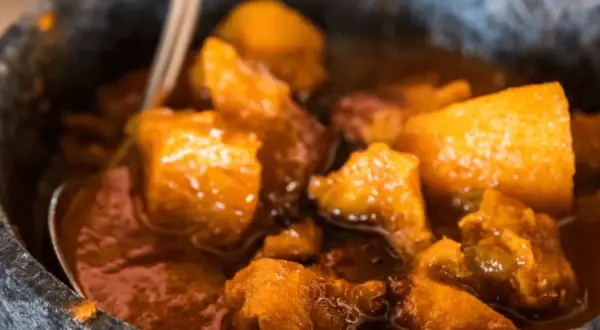 Un saporito spezzatino con patate, cotto lentamente e servito in una ciotola di pietra.