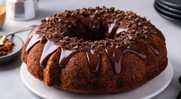 Torta al cioccolato con glassa lucida e riccioli di cioccolato, pronta per essere gustata.