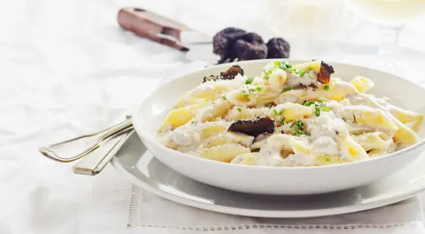 Penne cremose con funghi e tartufo nero, un piatto di pasta alla norcina che invita alla degustazione.