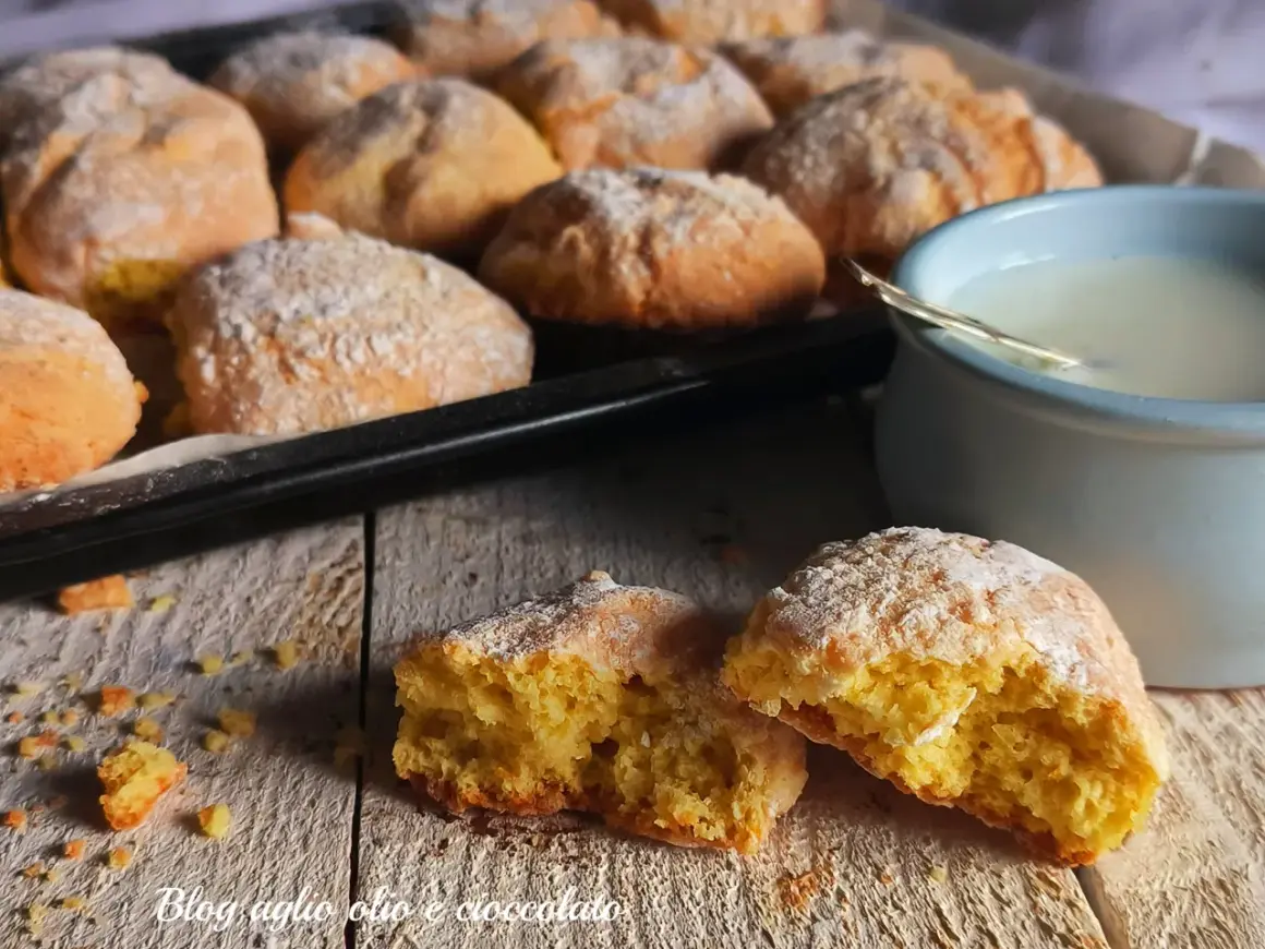 Biscotti al latte appena sfornati, spolverati di zucchero a velo, pronti per essere inzuppati in una tazza di latte caldo.