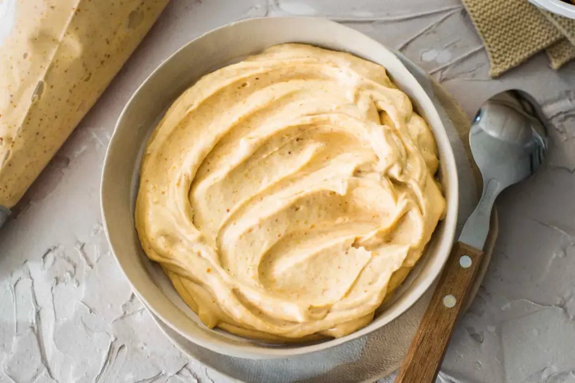 Crema soffice e invitante, perfetta per la tua burro di arachidi ricetta. Un cucchiaio attende di assaggiarla.
